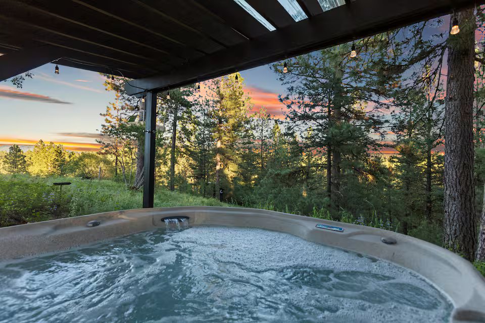 Hot tub with sunset glowing through the pine trees